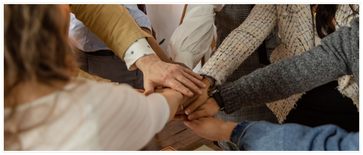 Careers - Hero Image - Group of  people communal handshake.
