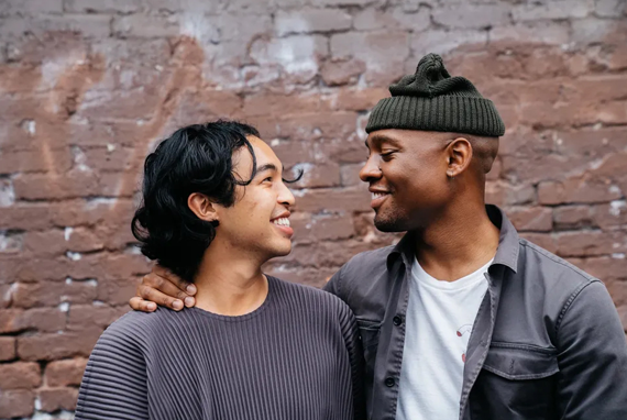 We are here for you - Image of a homosexual couple smiling looking at each other.